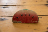 Vintage Mexican folk art clay watermelon bank with chipped red paint and black seeds.
