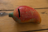 Chipped red clay, green stem, and coin slot of the vintage folk art piggy bank.