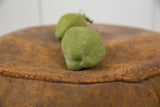 Textured green surface of a vintage Mexican folk art chayote piggy bank.