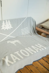 Light gray Katonah NY blanket with white horse, tree, wave motifs, and text.