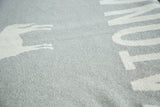 Katonah NY blanket, grey knitted texture with partial white deer silhouette and 'TON' lettering.