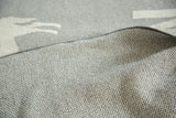 Katonah NY blanket, grey knitted texture featuring recycled cotton and light pattern.