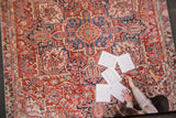 Coloring pages from the Old New House book spread across a vintage red and blue rug.