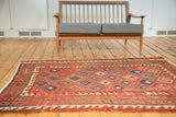 Antique Caucasian rug field with red lattice diamonds, contrasting wave borders, and evident foundation wear.