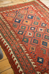 Antique Caucasian rug with ivory germinating plant border and teal wave motif.