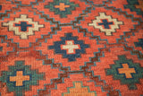 Antique Caucasian rug pile with geometric paneled diamond shapes in cherry red, navy, teal.
