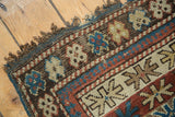 Hand-knotted antique Caucasian rug showing light tatter and geometric starburst bands.