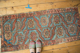 Antique Heriz fragment: sky blue field, geometric floral motifs, and rambling vine palmette border.