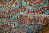 Antique Heriz rug fragment's seamed edge, showcasing sky blue, blush, red serrated leaf pattern.