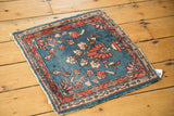 Vintage Lilihan rug corner shows tattered side, cranberry red border, and indigo floral field.