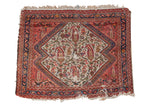Antique Persian Bag Face rug with ivory field, paisley diamond, and stepped dark rose borders.