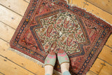 Antique Bag Face rug: ivory field, paisley boteh with arabesques, diamond border, visible wear.