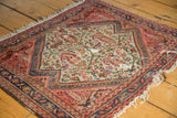 Antique Bag Face rug corner with paisley motif, stepped border, and worn foundation.