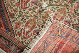 Antique Bag Face rug’s folded corner revealing detailed paisley, tattered fringe, and woven reverse.