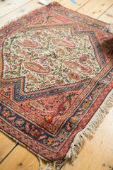 Antique Persian bag face rug corner with aged fringe, stepped border, and paisley boteh motifs.