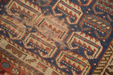 Antique Kurdish rug close-up: geometric patterns, indigo, madder red, and exposed foundation.