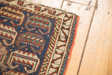Close-up: antique Kurdish rug's barber pole border, red side, and serrated leaf pattern.