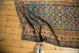 Kurdish vintage rug showing geometric patterns, decorative borders, navy, bronze, and beige tones.