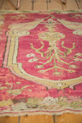Angled view of the etched, hand-knotted pile and tree-of-life design on a cochineal red antique rug.