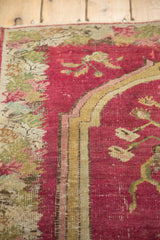 Close-up of the prayer-style border on an antique rug, showing etched knots and the underlying foundation.