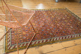 Dusty mauve antique Karabagh rug, repeating boteh trellis, and barber pole border.