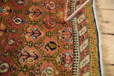 Antique Karabagh rug border detail: intricate barber pole pattern with gold, navy, and moss accents.