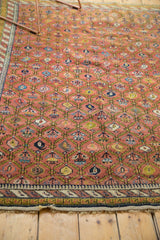 Antique Karabagh rug: dusty mauve field, repeating boteh, green lattice, barber pole border.