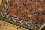 Intricate dusty mauve boteh motif and barber pole main border of a Persian Karabagh rug.