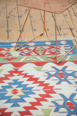 Serrated diamond, crab motifs, and vine border on vintage Kilim in red, blue, ivory, green.