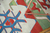 Serrated rectilinear patterns in cherry red, sky blue, and celadon green on a vintage Kilim.
