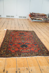 Rich brick red vintage Lilihan rug with ornate teal lotus and vase motifs.