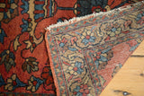Folded corner of the vintage Lilihan rug, showing hand-knotted weave, fringe, and floral pile.