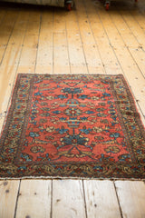 Vintage Lilihan rug corner: brick red field, teal lotus, and ornate border with light tatter.