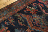 Vintage Mehreban rug detail: aged indigo blue field with bronze reptile and finned floral motifs.