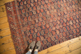 Antique Afshar rug fragment with allover red and indigo boteh pattern and visible textural wear.