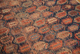 Afshar rug fragment showing repeating boteh pattern, worn texture in indigo and madder red.