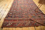 Antique Afshar rug fragment's intricate geometric borders and repeating madder red boteh motif.