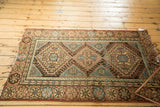 Vintage Hamadan rug's dusty apricot diamond medallions and reciprocating wave border.