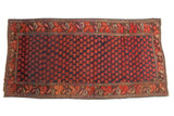 Antique Karabagh carpet, deep indigo field, allover repeating red floral motif, colored leaf border.