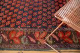 Antique Karabagh carpet border featuring rich red botanical motifs and indigo field.