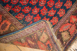 Folded corner of antique Karabagh rug, revealing rich indigo floral pile and detailed woven foundation.