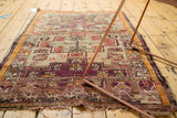 Antique Caucasian rug's tattered fringe, visible foundation, with aubergine, silver, tangerine pattern.