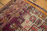 Antique Caucasian rug's geometric vinery, aubergine and silver tones, with visible foundation.