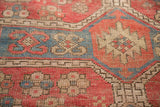 Worn pile of vintage Caucasian rug, featuring light blue, dusty rose, and beige geometric pattern.