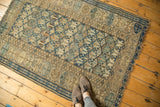Antique Caucasian rug field: geometric stylized buds in indigo, beige, with wear and tattered ends.