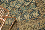 Geometric stylized buds in indigo, sky blue, and ivory on antique Caucasian rug with knot head wear.