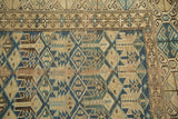 Visible wear on antique Caucasian rug showing geometric indigo and sky blue patterns.