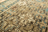 Antique Caucasian rug detail featuring stepped medallions, blossomed plants, beige, and sky blue.