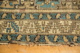 Frayed lower edge of antique Caucasian rug, geometric border in sky blue, beige, and dark brown.