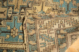 Antique Caucasian rug: teal and beige geometric pattern, hand-knotted back, and worn edge.